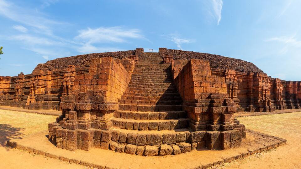 A large, ancient brick structure with a central staircase and surrounding walls.