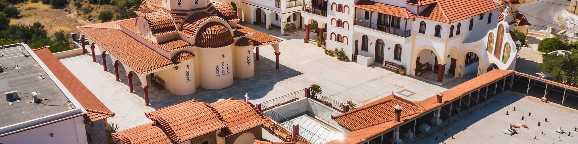 A church with a bell tower and a courtyard.