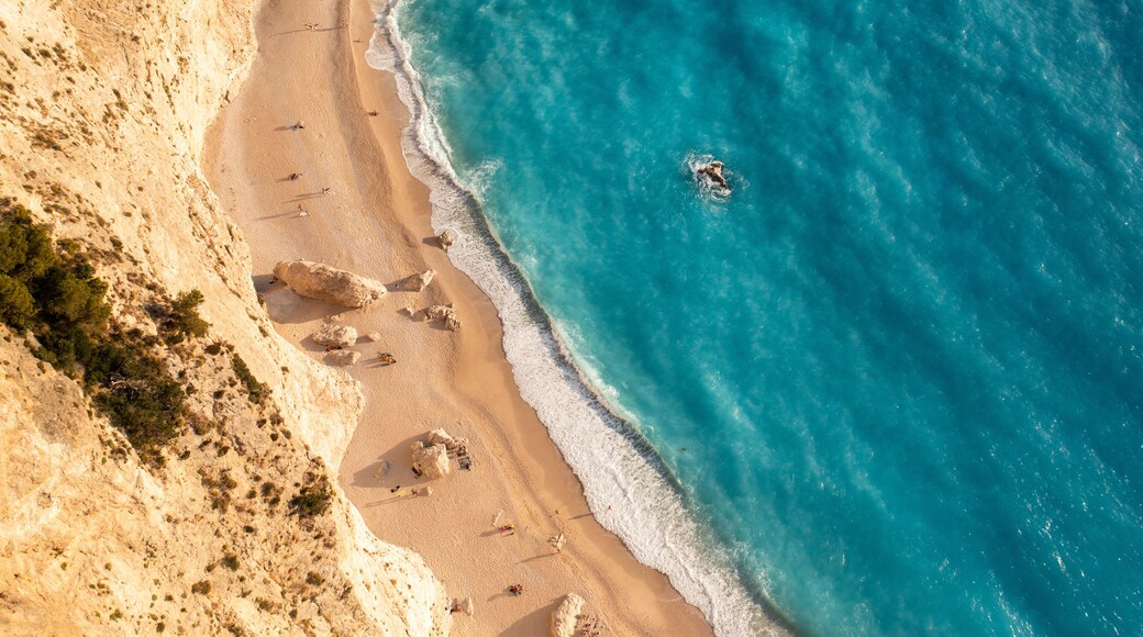 Aerial view of beautiful sandy beach and azure sea with cliffs and waves, Athani, Greece.