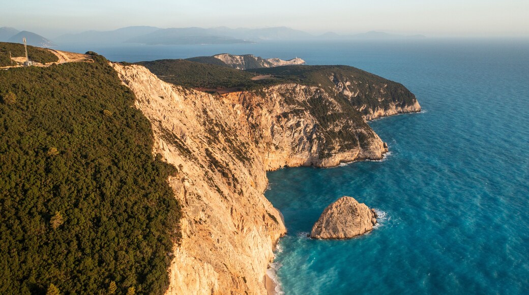 Aerial view of beautiful rocky coastline and tranquil ocean waves, Athani, Greece.