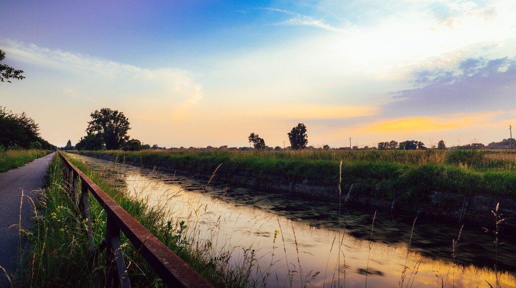 Empty cycling path along the Naviglio Pavese, canal at sunset. The canal stretches for 30km from Pavia to Milan in Lombardy, northern Italy.