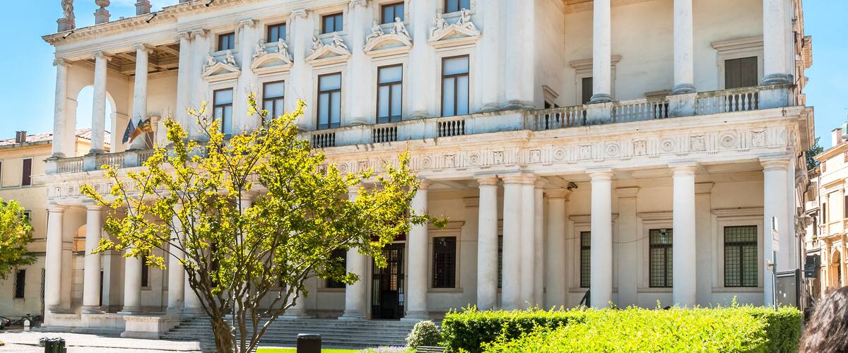 A grand neoclassical building with columns and statues.