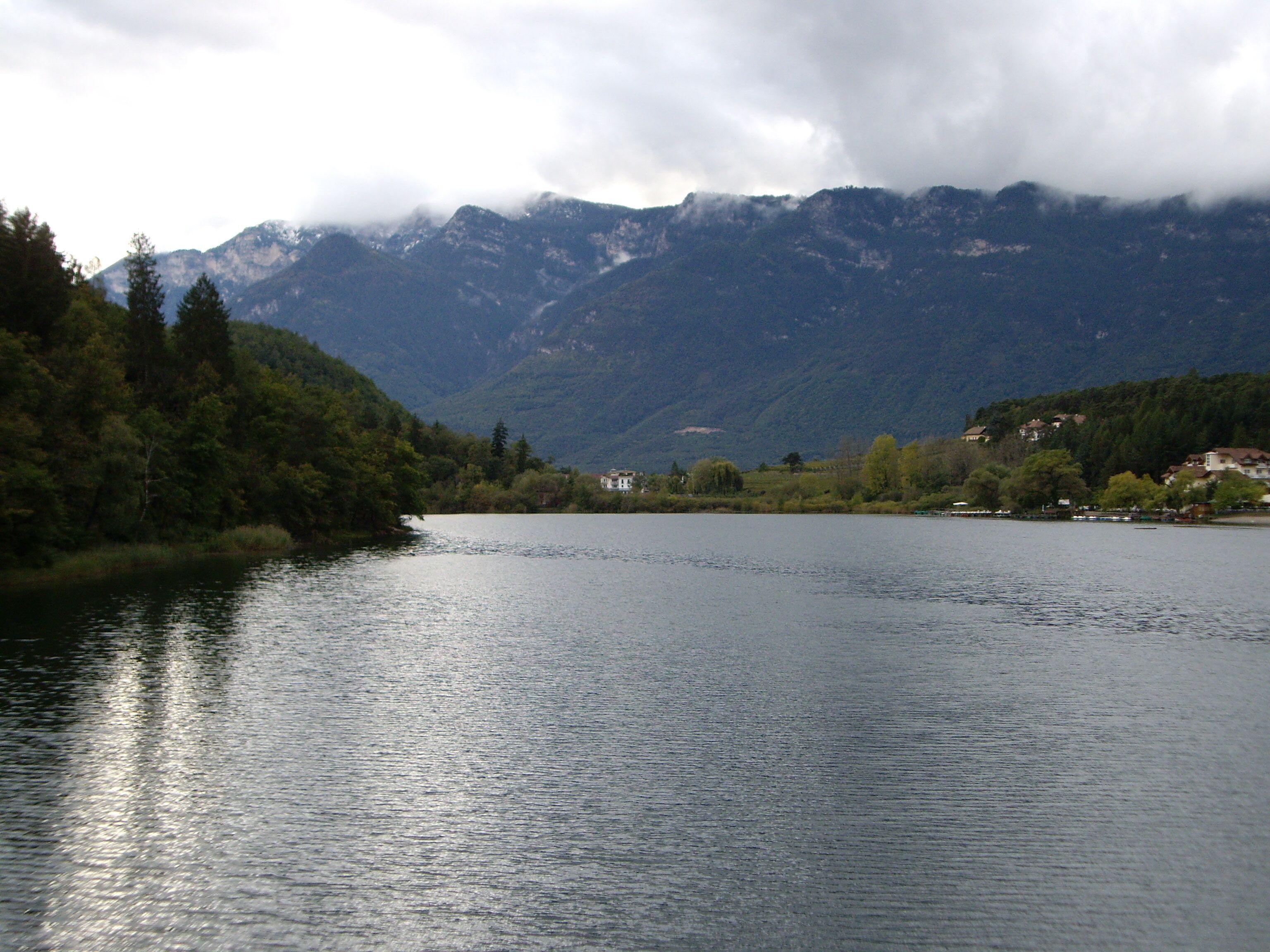 A calm lake surrounded by mountains and trees.