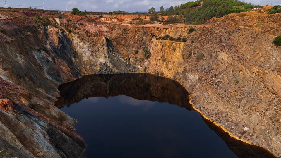 A large open-pit mine with steep, rugged walls and a deep pit.