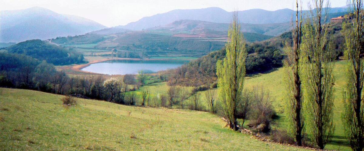 A lake surrounded by hills and trees.