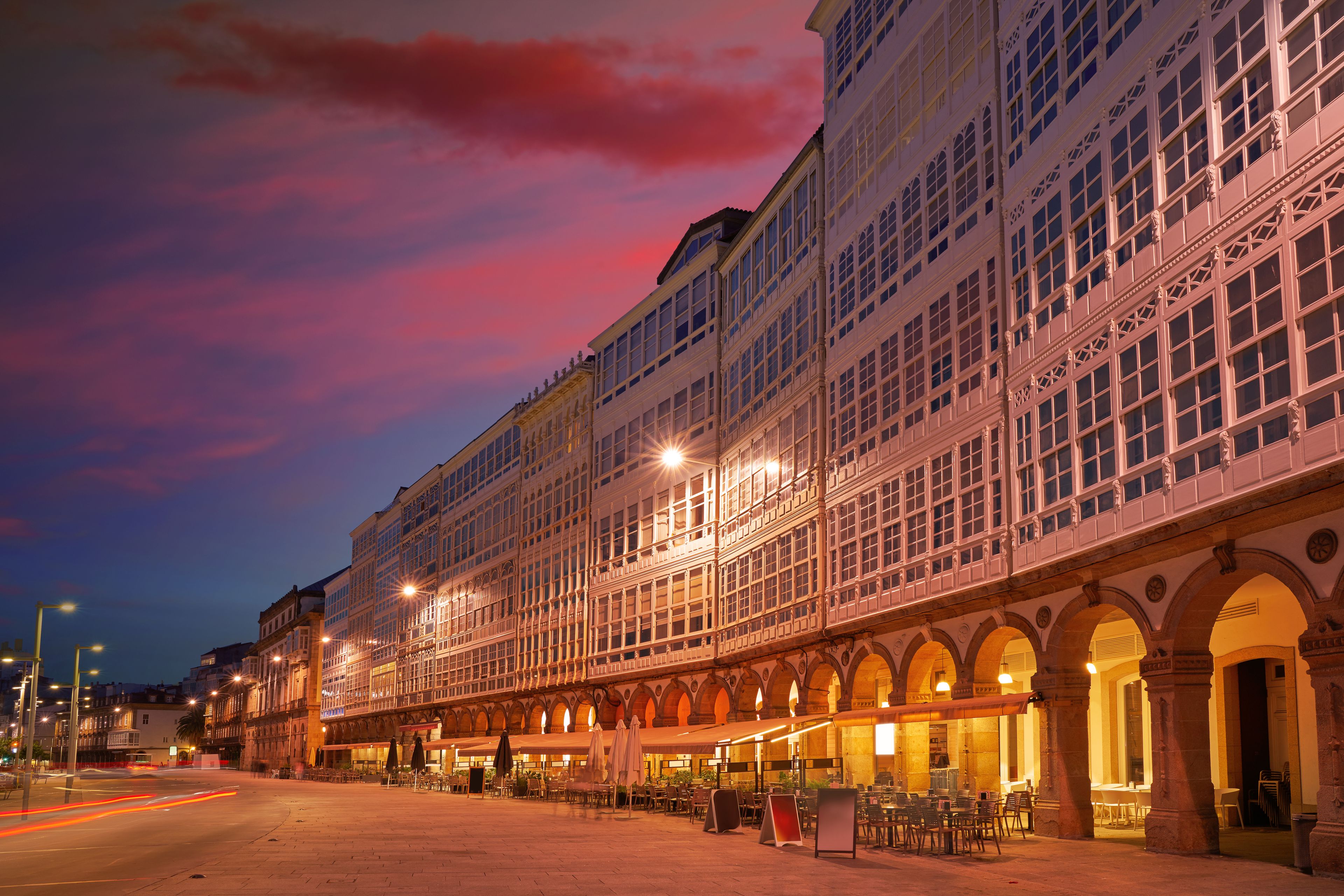 A historic building with ornate architecture and a row of outdoor seating.