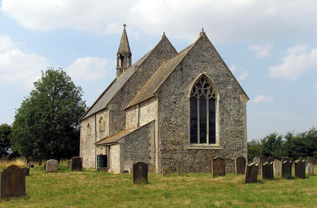 A stone church with a bell tower and a graveyard.