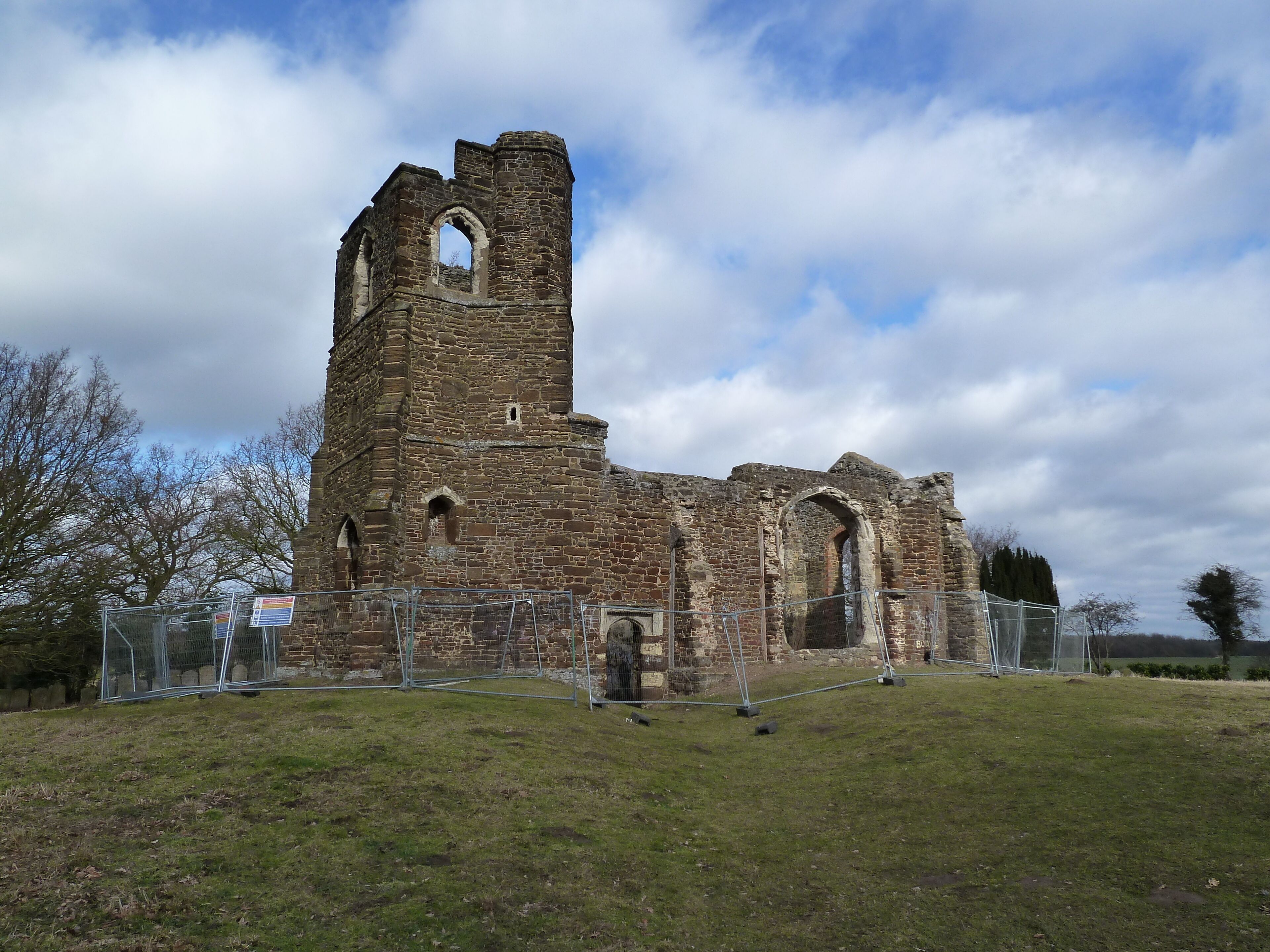 An old stone church with a tall bell tower and arched windows.