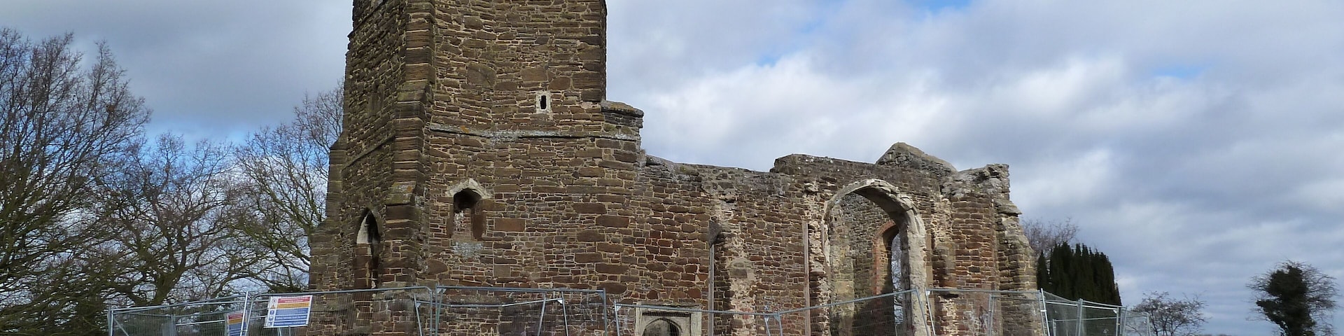 An old stone church with a tall bell tower and arched windows.
