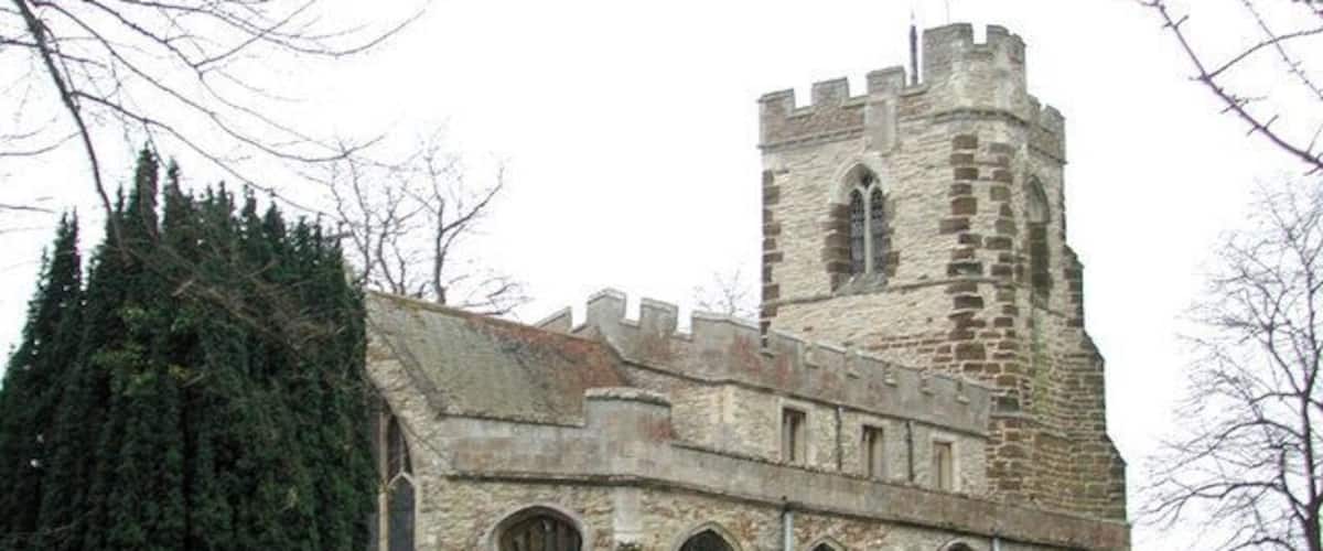 A historic stone church with a prominent tower and arched windows.