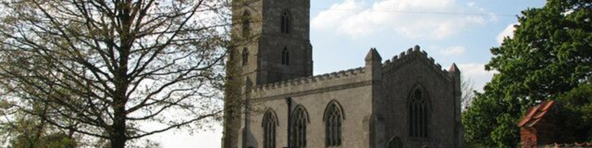Una iglesia histórica con una torre alta y ventanas de arco.