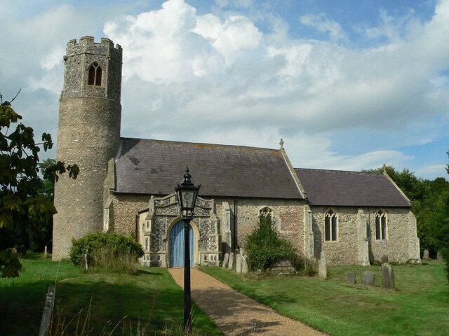 A stone church with a tower and a blue door.