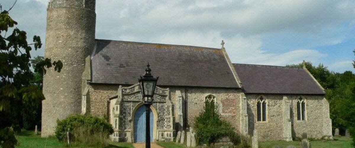 A stone church with a tower and a blue door.