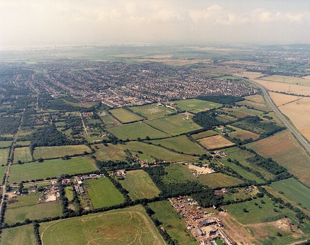 Aerial view of New Thundersley and Plotlands from the north-east. This image is taken from a point to the west of 1559136, and shows more land to the north of that (bottom of the picture). To the bottom right is Lychgate Farm. The tracks in the field to the left of this were probably made by motor cycles. (At the time many of these fields were used by unlicensed motor-bikes.) The A130 runs along the right edge, and along the left edge is Coniston Road.