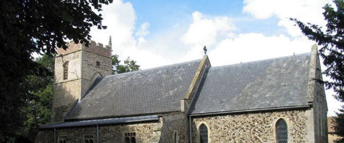 A stone church with a tower and arched windows.