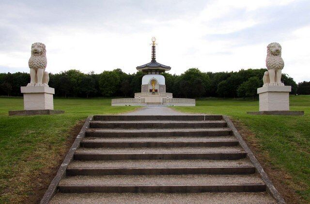 Un temple amb una pagoda, envoltat d'estàtues i un camí.
