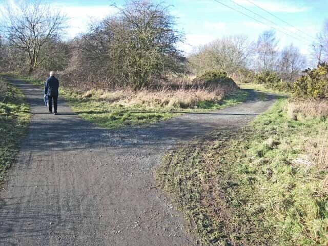 A rural road with a person walking on the left side.