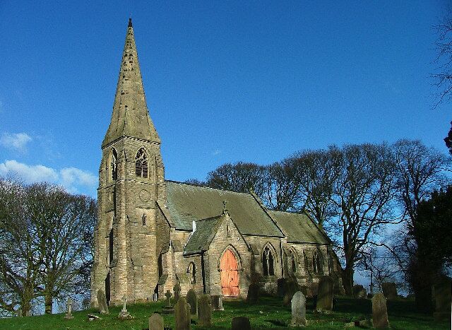 A historic church with a tall spire and a large arched entrance.