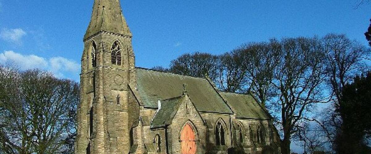 A historic church with a tall spire and a large arched entrance.