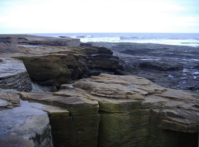 Low cliffs, near Newbiggin Point. Some reinforcement has been used to counter the storm waves.