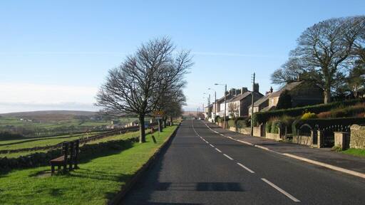 B6282 through Woodland Road through village with Woodland Fell in the background