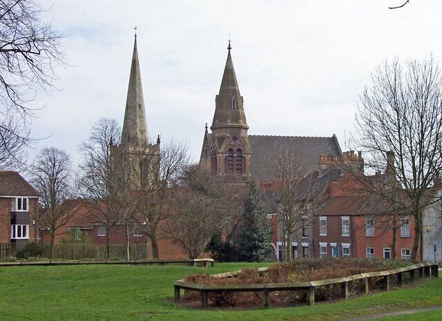 Twin Spires, Hessle, East Riding of Yorkshire, England. On the left is All Saints whilst to the right is the Wesleyan Methodist church. Photo taken from Trinity Grove looking across Tower Hill Memorial Park. Concrete garden bed fence.