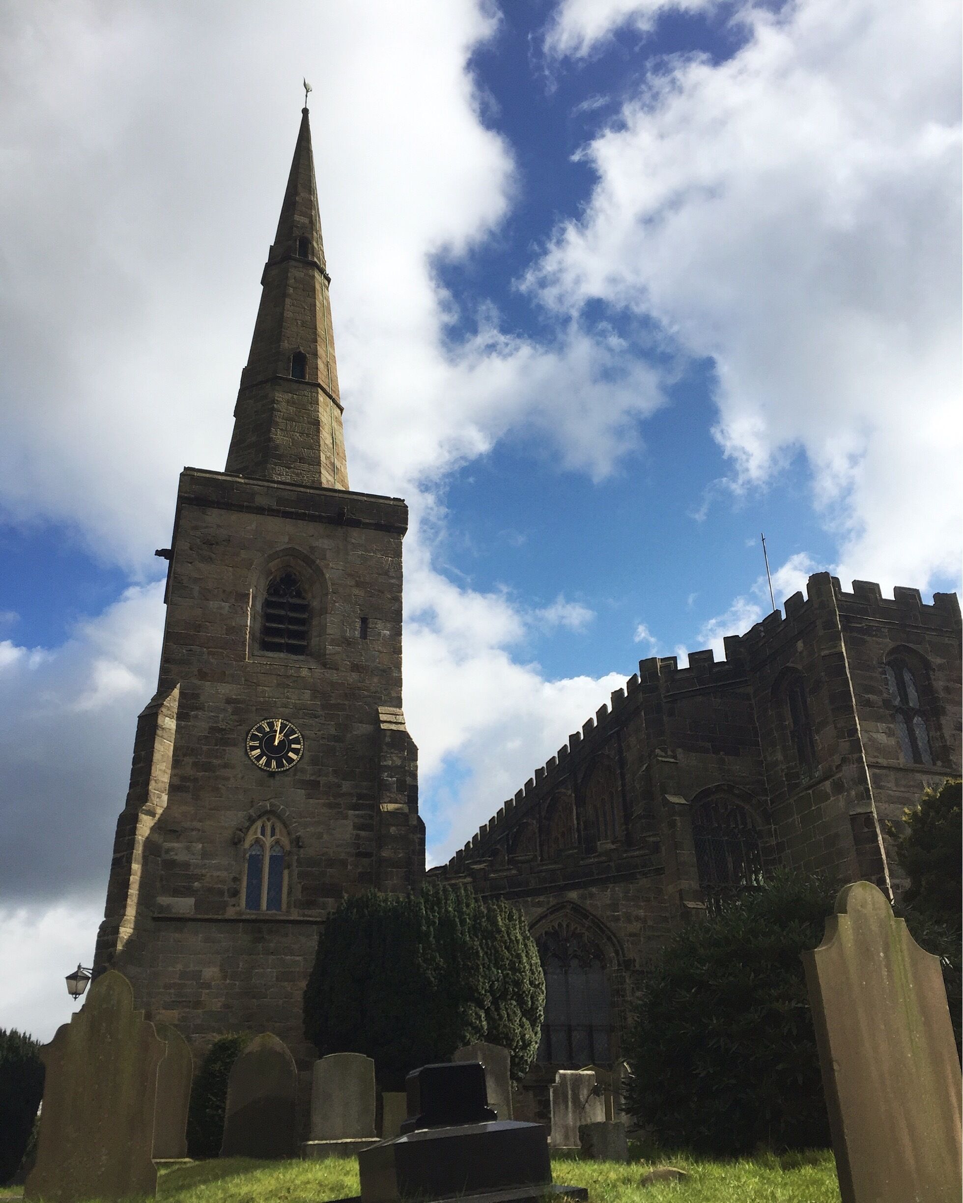 A church with a tall spire and a clock.
