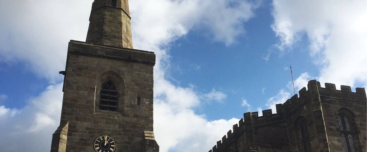 A church with a tall spire and a clock.