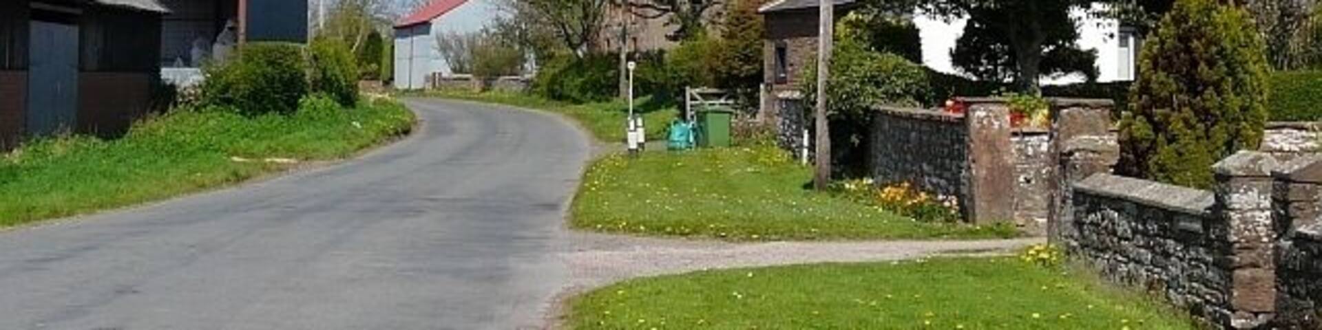 Road through Brisco, near to Brisco, Cumbria, Great Britain. Brisco is a pleasant-looking hamlet about 4km south east of Carlisle. It has several farms and a brickworks.