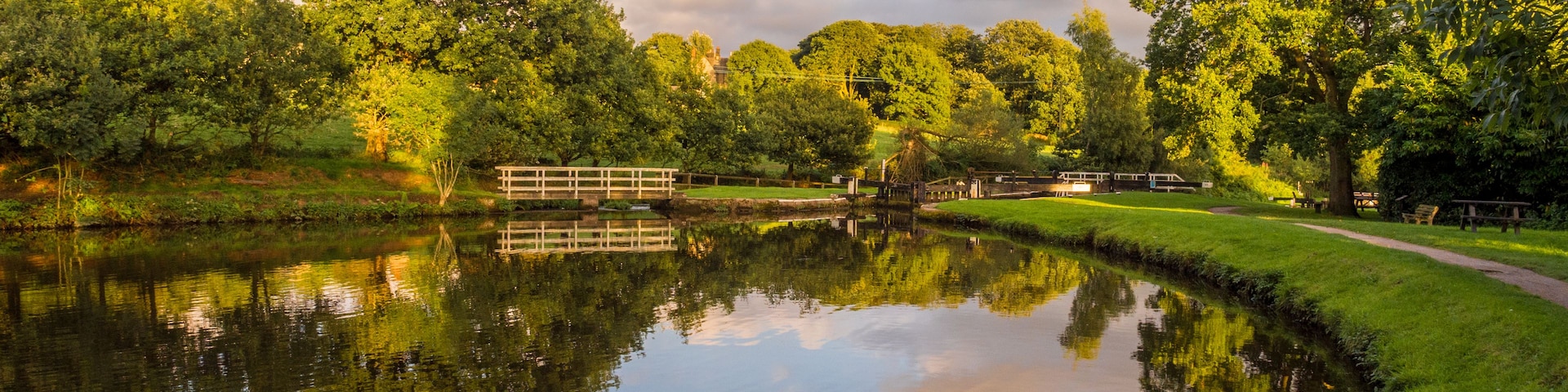 Un río tranquilo que refleja árboles y un puente.