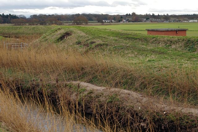 Pumping Station on the River Alt The protective banks stand about three metres above the surrounding land. The land itself would be more marsh than farmland if it weren't for these and the constant pumping of water from the land drains into the river.