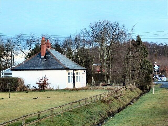 The White House. Looking north up the A7 at Harker. Small white bungalow is adjacent to the filling station.