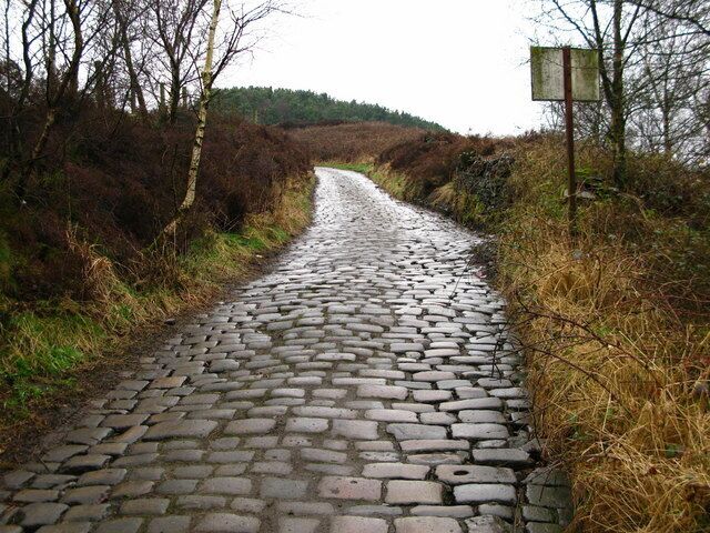 Bridleway on Rough Bank Leading from Ogden Lane up Rough Bank. A nearby sign suggests the cobbles are maintained by the Pennine Township Committee.