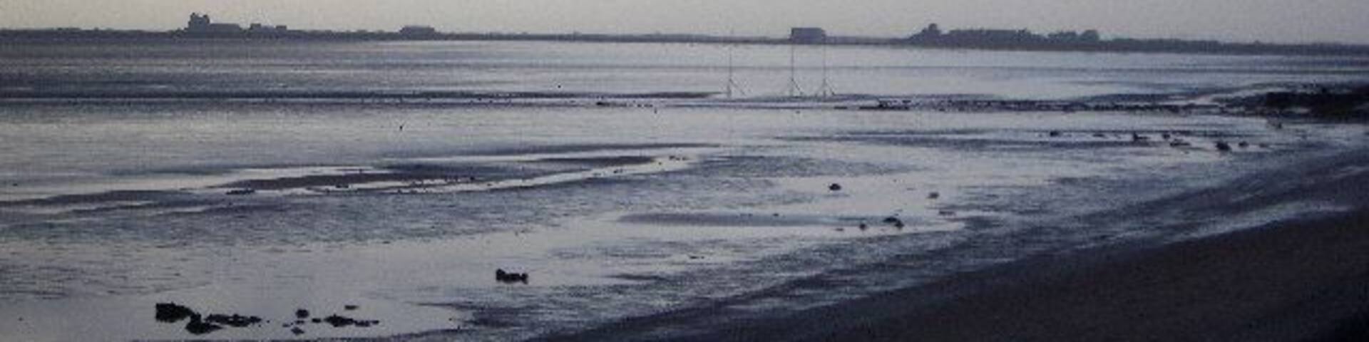 From Rampside towards Piel. This picture was taken from the coast road looking towards Piel Island. Roa Island and the lifeoat station can be seen on the horizon.