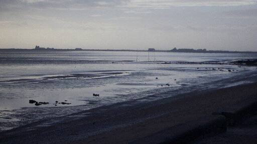 From Rampside towards Piel. This picture was taken from the coast road looking towards Piel Island. Roa Island and the lifeoat station can be seen on the horizon.