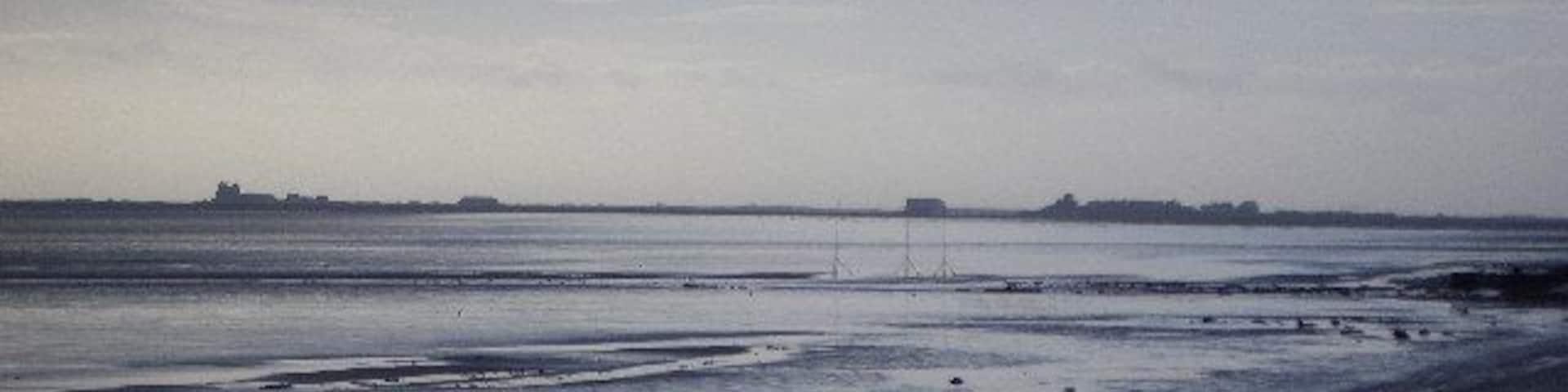 From Rampside towards Piel. This picture was taken from the coast road looking towards Piel Island. Roa Island and the lifeoat station can be seen on the horizon.