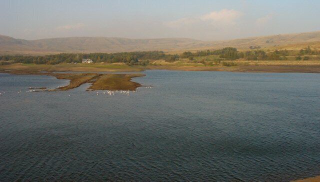 Watergrove Reservoir, Lancashire. View of the reservoir, looking N from the top of the dam. The car park is behind the photographer. The water is very low and the line of the old road that used to give access up the valley can be seen in the temporary island in the reservoir.