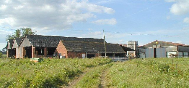 A rural farm with a large barn, a smaller building, and a silo.