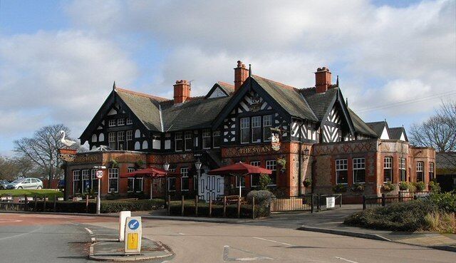 A traditional Tudor-style building with a sign that reads "The Swan."