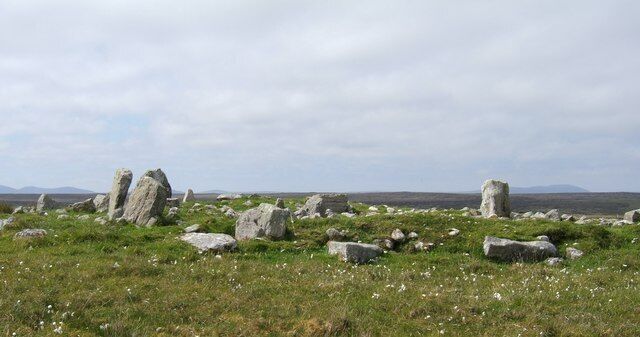 A grassy field with several large standing stones.