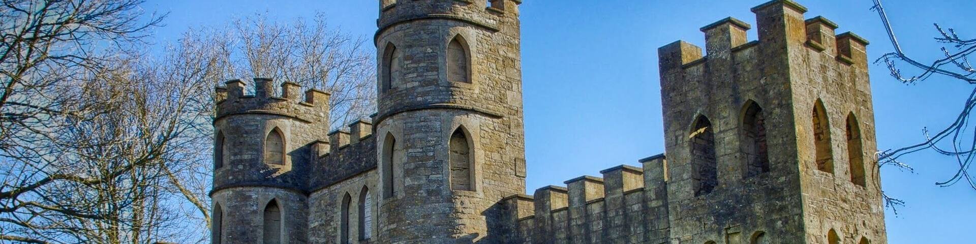 A historic stone castle with multiple towers and arched windows.
