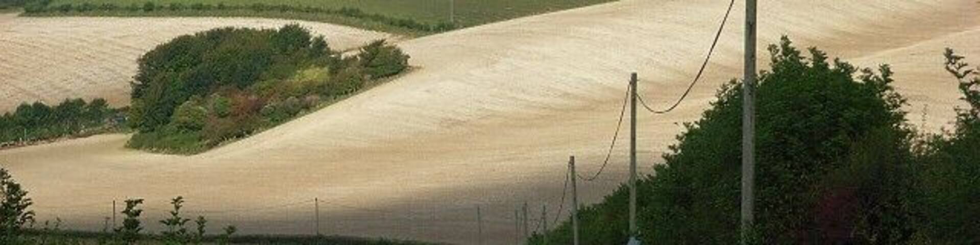 Downland, Bincombe The sun breaks through to reveal a dramatic scene on the descent from Bincombe towards Lower Bincombe and Upwey. The chalky soil is very much in evidence after ploughing.