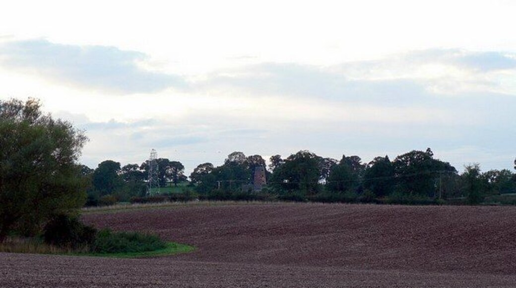 Ploughed field and the view to the mill at Butter Hill House. Looking from the lane from The Toft to Coppenhall. The mill among the trees is at SJ898181