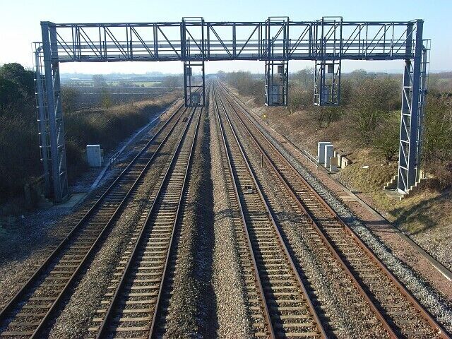 Railway near Grove The view west from Denchworth Road Bridge is immediately interrupted by a signal gantry for eastbound trains.