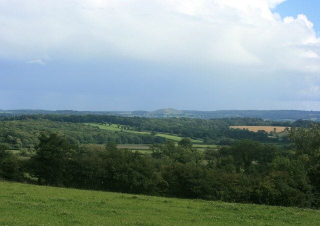 South east from Fulwell Lane Where it crosses Chickwell Lane. The scene is darkened by an approaching thunderstorm but Cley Hill ST8344 is far enough to find a gap in the clouds.