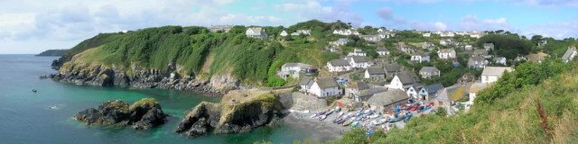 Panoramic view of Cadgwith looking towards Lizard Point The white marquee just visible in the horizon on the far left is the venue for the wedding of the century, James and Jo, 12th August 2006