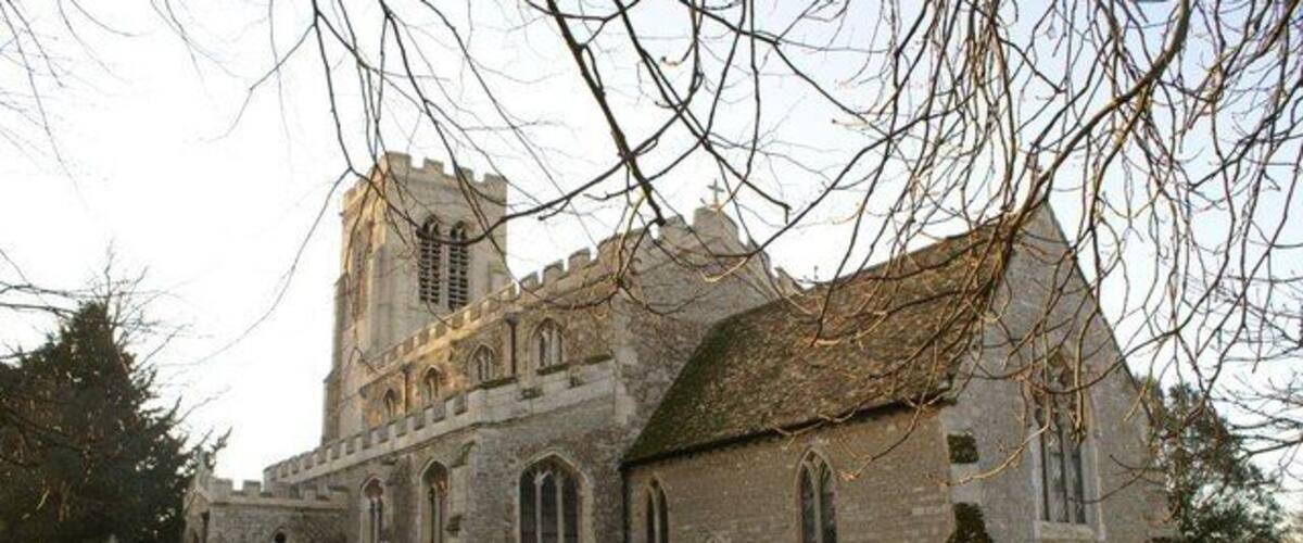 A historic church with a large tower and multiple tombs in the foreground.