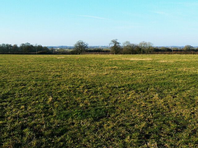 Farmland near Highway There is a bridleway not far away. Its location is marked by the line of trees on the other side of the field.