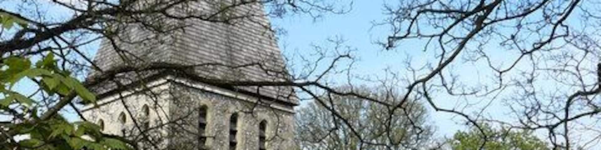A stone church with a pointed steeple and arched windows.