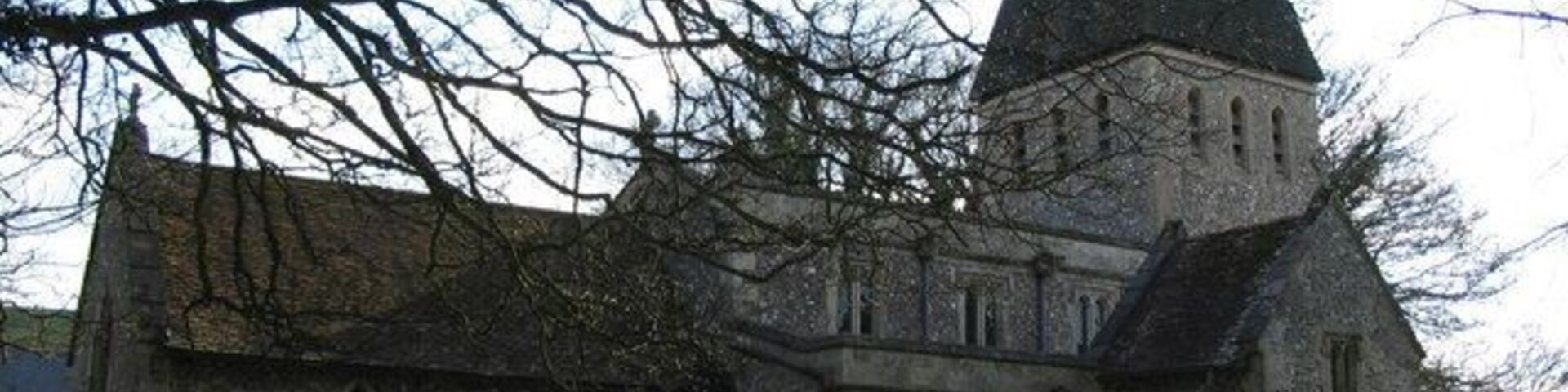 All Saints, Idmiston. A view looking south over the graveyard to All Saints church. The church was last used for a Thanksgiving service at the golden Jubilee in 2002 and is now 'redundant'. Visitors may gain access by following the instructions in the porch to obtain the key.
